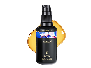 Flacon pompe noir avec texte blanc, placé à côté d'une orange tranchée. Le produit semble être un produit de soin de la peau ou un produit cosmétique.