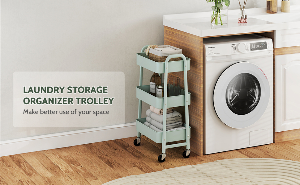 Chariot roulant vert menthe à trois niveaux pour le rangement du linge à côté d'une machine à laver blanche à chargement frontal. Le chariot contient des serviettes pliées et des produits de lessive dans une pièce revêtue de parquet