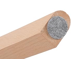 Gros plan d'une butée de porte en bois ou d'un pied de meuble. Design effilé avec un tampon circulaire en feutre gris fixé à une extrémité pour protéger le sol