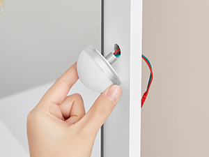 une main enfonçant une poignée de porte dans une porte.