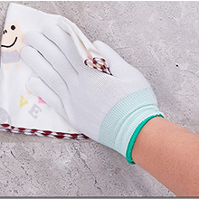 Gros plan d'un gant médical ou de travail blanc avec manchette élastique vert menthe et motif décoratif