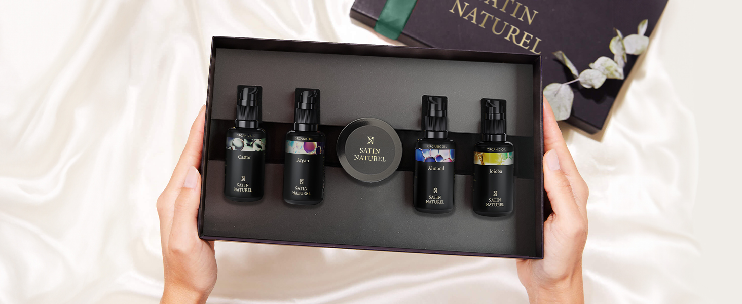 Coffret cadeau contenant cinq flacons en verre d'huiles essentielles ou de parfums. L'ensemble comprend des bouteilles foncées avec compte-gouttes, présentées dans un élégant emballage noir