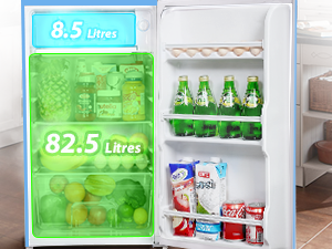 Réfrigérateur ouvert présentant un intérieur avec des compartiments éclairés en vert. La partie supérieure montre une capacité de 8,5 litres, la partie inférieure de 82,5 litres. Les étagères contiennent divers produits alimentaires et boissons.