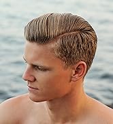 Profil latéral rapproché d'une courte coiffure brune avec un quiff bien stylisé et des côtés effilés, sur un fond d'eau flou