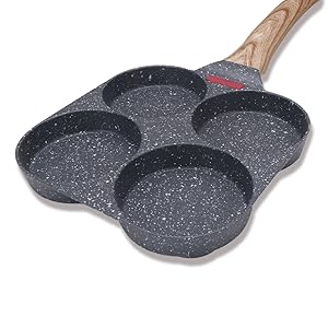 Poêle à plusieurs compartiments avec quatre sections circulaires. Surface antiadhésive foncée, manche en bois. Conçu pour cuire plusieurs plats simultanément.