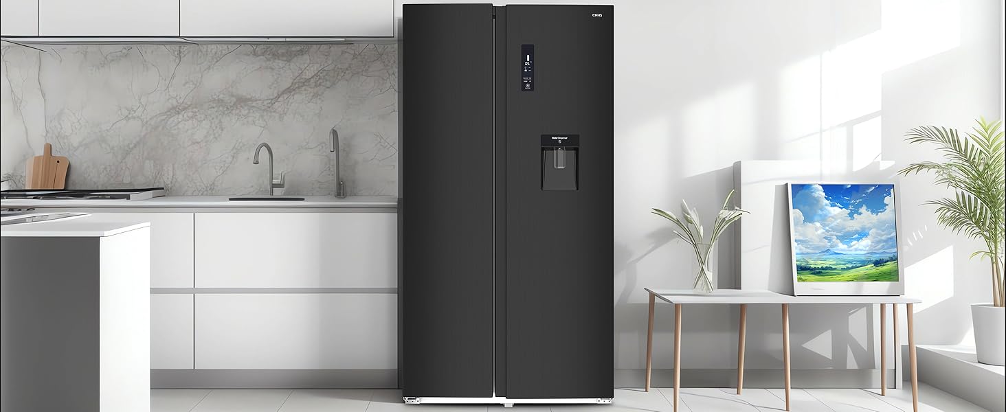 Cuisine moderne avec armoires blanches, dosseret en marbre et grand réfrigérateur noir avec distributeur d'eau. Œuvre encadrée visible.