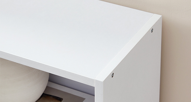 Gros plan d'une surface blanche ou d'un bord de table, montrant un minimum de détails et des lignes épurées sur un fond neutre