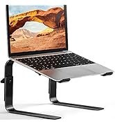 avec pieds incurvés en métal noir. Un ordinateur portable argenté sur support affiche un paysage désertique avec une arche rocheuse. Le support permet de surélever l'ordinateur portable pour une utilisation ergonomique