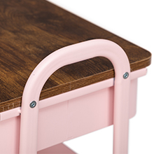 Gros plan d'un manche en métal rose fixé à une surface en bois, probablement une partie d'un meuble ou d'un équipement