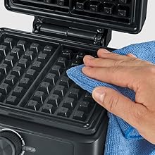 Séquence montrant le nettoyage d'un gaufrier ou d'une surface de cuisson texturée à l'aide d'un chiffon bleu sur des plaques antiadhésives noires.