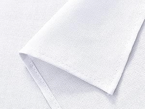 Gros plan d'un tissu textile blanc montrant un motif de tissage détaillé et un bord plié, démontrant la texture et l'épaisseur du matériau