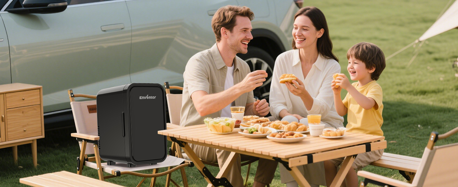 à côté de la table à manger extérieure avec la famille en train de prendre un repas en camping-car. Glacière noire visible sur le côté gauche de la table en bois avec de la nourriture et des boissons.