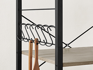 Gros plan d'un support en métal noir avec crochets incurvés. Un cintre en bois est visible, suggérant une solution de rangement pour manteaux ou vêtements