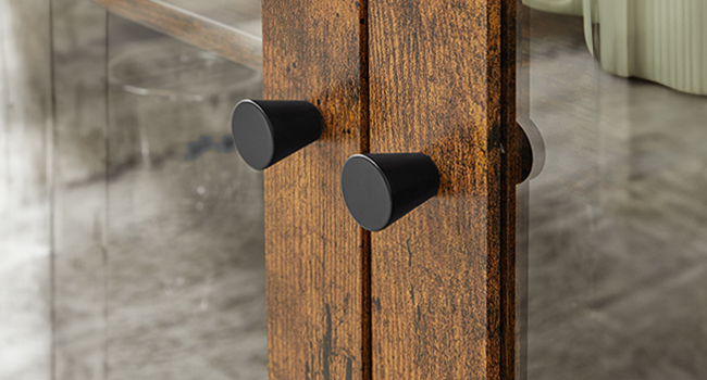 Gros plan de deux petits objets noirs en forme de cône fixés à une surface en bois, peut-être des butées de porte