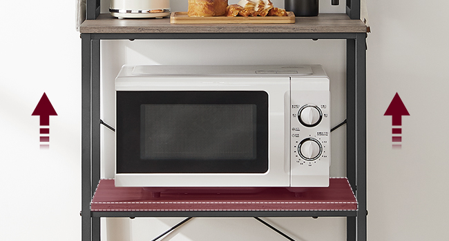 Four à micro-ondes blanc sur une étagère en métal avec plateau en bois. Les flèches rouges indiquent une hauteur ajustable. Articles de cuisine visibles sur l'étagère supérieure.