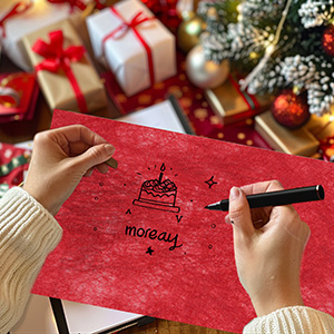 Serviette ou papier rouge avec une illustration de gâteau d'anniversaire en cours d'écriture, entourée de cadeaux de Noël et de décorations dans un cadre festif