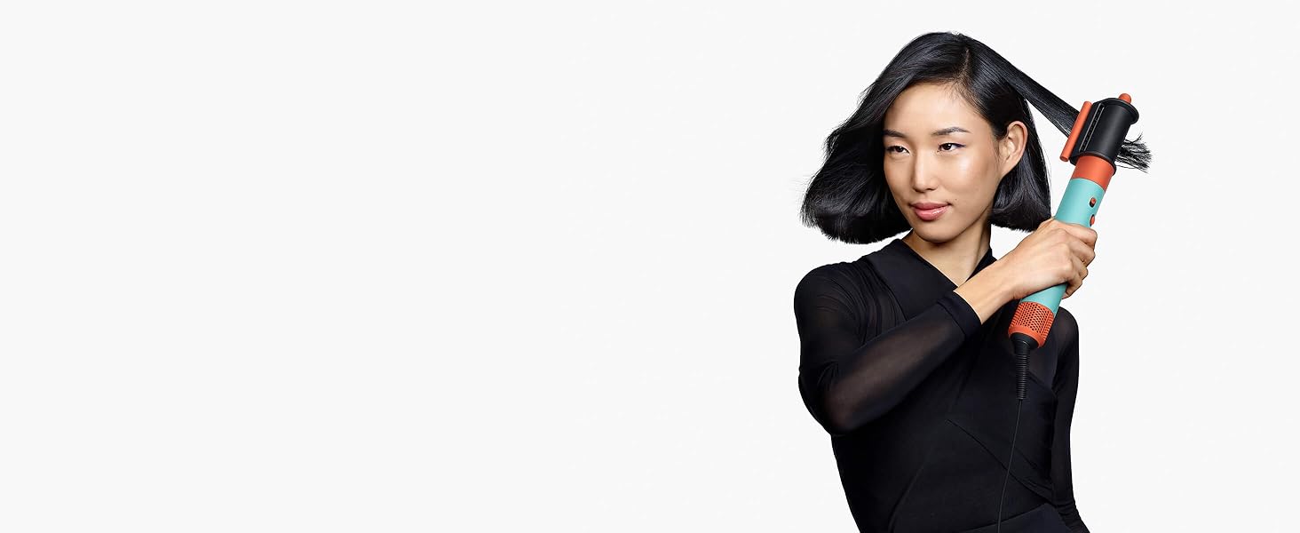 Un mannequin aux cheveux bruns mi-longs utilise l’embout de séchage lissant Coanda.