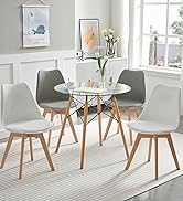 une table ronde en verre et des chaises installées dans un salon.