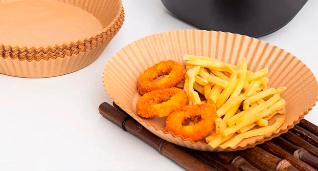 Plateau alimentaire en papier cannelé orange contenant des rondelles de calmars frits et des frites, posées sur une surface en bois