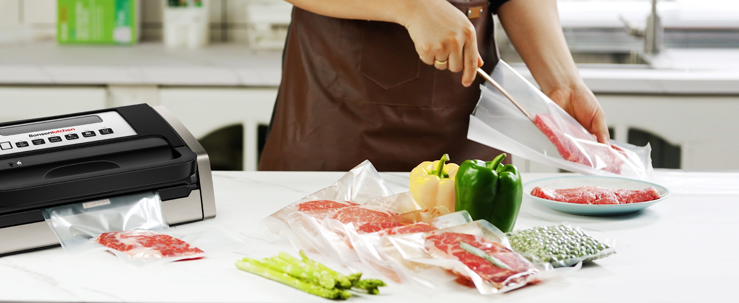 Scène de cuisine avec des mains utilisant une scelleuse sous vide pour emballer de la viande crue. Divers produits alimentaires et matériaux d'emballage visibles sur le comptoir