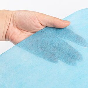 une main tient un linge mouillé.