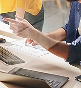 un homme et une femme assis à un bureau devant un ordinateur.
