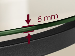 Gros plan du bord d'un produit, montrant un espace de 5 mm entre les couches verte et noire, indiqué par des flèches rouges et du texte