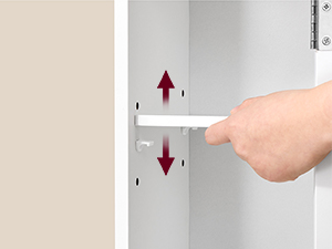 une main tenant une poignée de porte avec une poignée en plastique blanc pointant vers le bas.