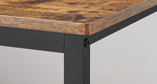 Gros plan d'un coin de table, montrant un plateau en bois épais dont le grain est visible. Monture en métal noir visible en dessous, suggérant un design industriel ou moderne.