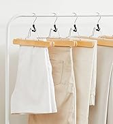 Quatre cintres en bois à clips affichant des échantillons de tissus ou de vêtements blancs et beiges sur fond blanc