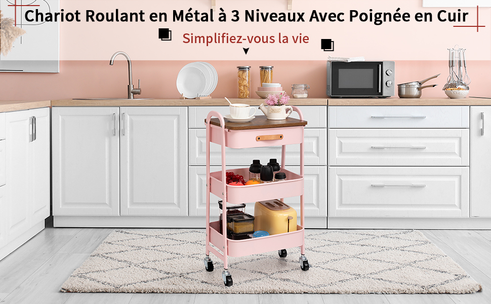 Chariot roulant en métal à trois niveaux avec poignée en cuir dans une cuisine blanche. Les étagères roses contiennent des articles de cuisine. Armoires et appareils blancs visibles en arrière-plan.