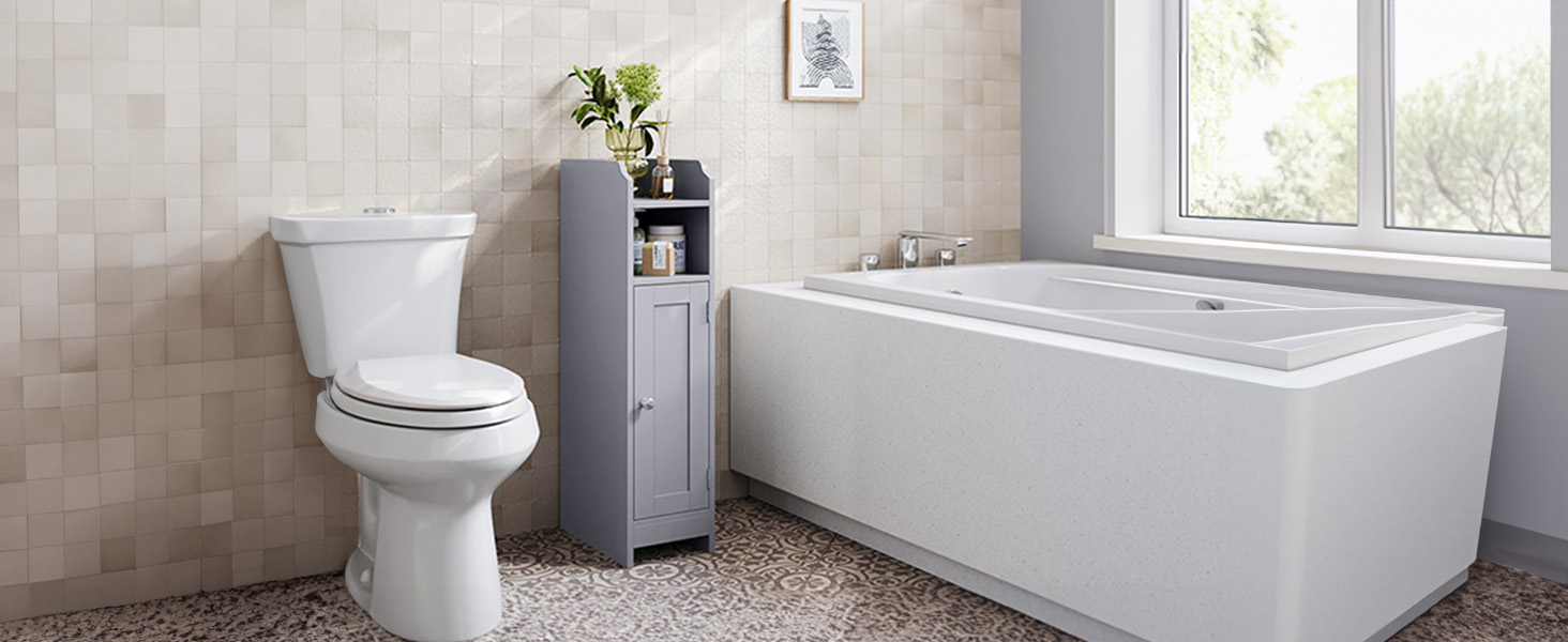 Intérieur de salle de bain moderne comprenant une baignoire rectangulaire blanche, des toilettes blanches et une armoire de rangement grise contre des murs carrelés beiges avec éclairage naturel provenant de la fenêtre.