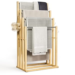 Porte-serviettes en bois avec serviettes gris clair exposées. Dispose d'un design minimaliste avec des barres horizontales en bois au fini naturel.