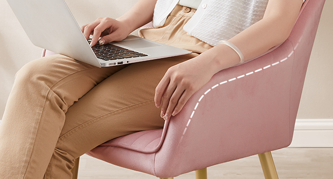 Fauteuil d'appoint rembourré rose avec pieds en bois, illustré avec une vue partielle d'une personne utilisant un ordinateur portable.