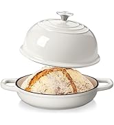 Plat de cuisson en céramique blanche avec poignées et couvercle bombé montrant du pain artisanal croustillant à l'intérieur. Le couvercle est doté d'anneaux concentriques et d'une poignée à bouton sur le dessus.