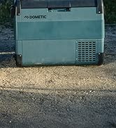 sur sol sablonneux. Extérieur bleu-vert clair avec grille de ventilation sur le côté. Conception robuste adaptée à une utilisation en extérieur.