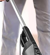 une personne utilisant un aspirateur sur une table.