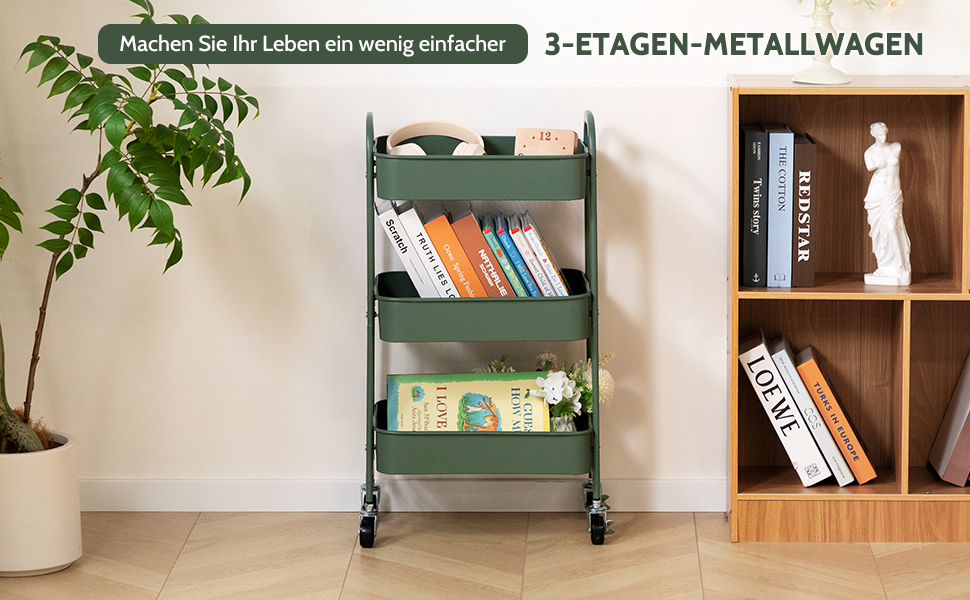 Chariot utilitaire à trois niveaux en métal vert sur roues. Le chariot contient des livres et des objets de décoration. Placé à côté d'une étagère en bois et d'une plante en pot à la maison