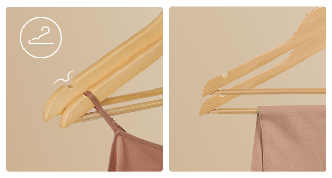 Deux porte-manteaux en bois tenant un vêtement rose. Vue rapprochée montrant les crochets et les épaules des cintres sur fond beige