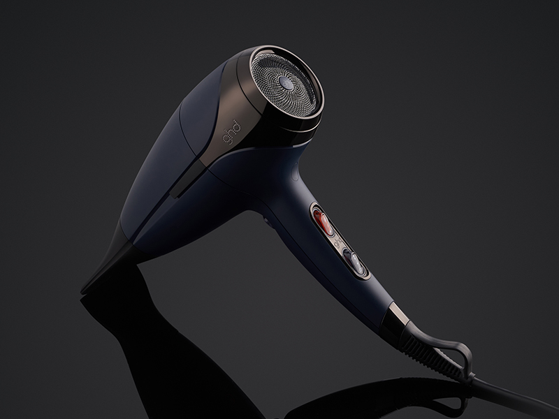 Sèche-cheveux professionnel noir sur fond sombre, présentant un design élégant avec embout concentrateur.