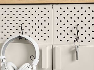 Panneau perforé blanc avec motif à pois. Les accessoires à suspendre comprennent des écouteurs blancs et de petites pochettes ou étuis. Vue partielle de la solution de stockage organisée.