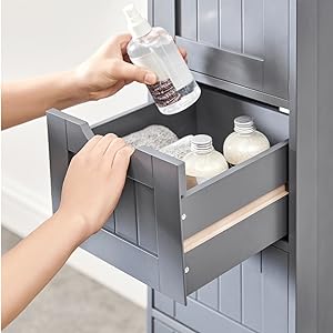 une main tenant une bouteille de désinfectant pour les mains dans une armoire de toilette