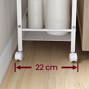 Gros plan d'un chariot ou d'une étagère à roues blanc, montrant sa largeur de 22 cm entre les roues sur un plancher en bois