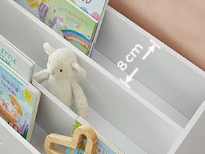 Gros plan d'une étagère blanche à compartiments. Une mesure de 8 cm est indiquée sur une étagère. Un petit agneau en peluche et des livres pour enfants sont visibles.