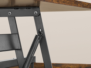 Détail rapproché d'un mécanisme de pliage en métal noir avec ressorts et charnières visibles montés sur ce qui semble être un meuble en bois