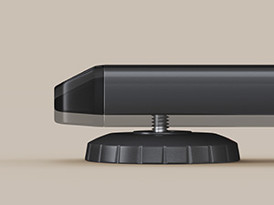 Vue rapprochée d'un appareil électronique noir avec une base circulaire ajustable, probablement un haut-parleur ou un petit appareil, sur une surface de couleur claire