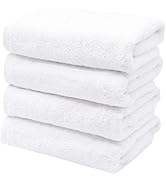 Pile de cinq serviettes de bain blanches pliées. Texture duveteuse visible sur les bords. Les serviettes semblent épaisses et absorbantes.