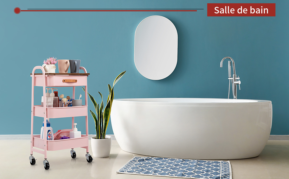 Salle de bain moderne avec baignoire autoportante blanche, miroir ovale et chariot roulant rose. Carrelage mural et sol à motifs bleus. Texte « Salle de bain » visible.