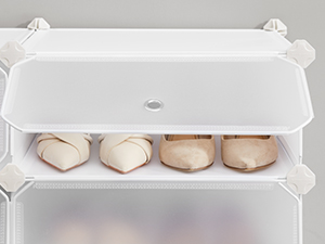 Plusieurs plans de produits montrant un contenant de rangement en plastique ou en céramique blanc aux coins arrondis et doté d'un couvercle, vide et rempli d'œufs sous différents angles.