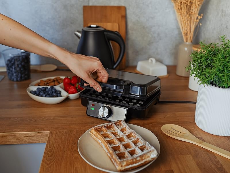 Séquence d'images montrant des mains interagissant avec un appareil de cuisine ou de cuisine posé sur un plan de travail en bois avec des plantes en arrière-plan.